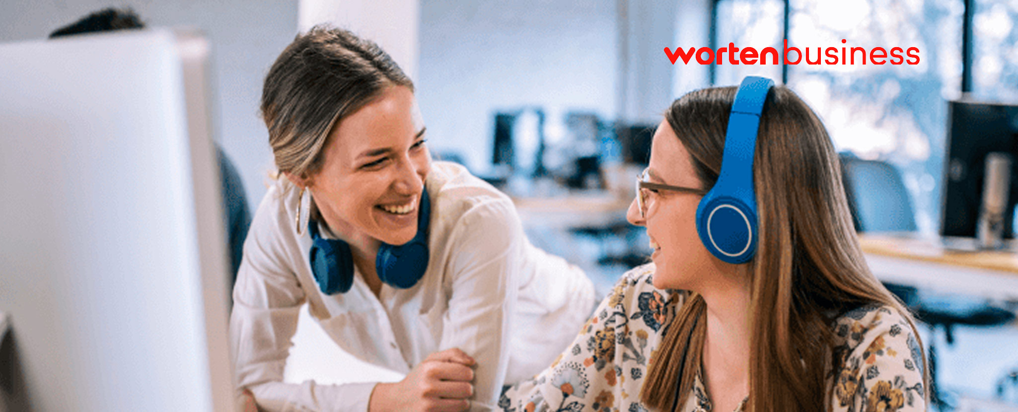 duas mulheres à conversa e sorridentes no trabalho