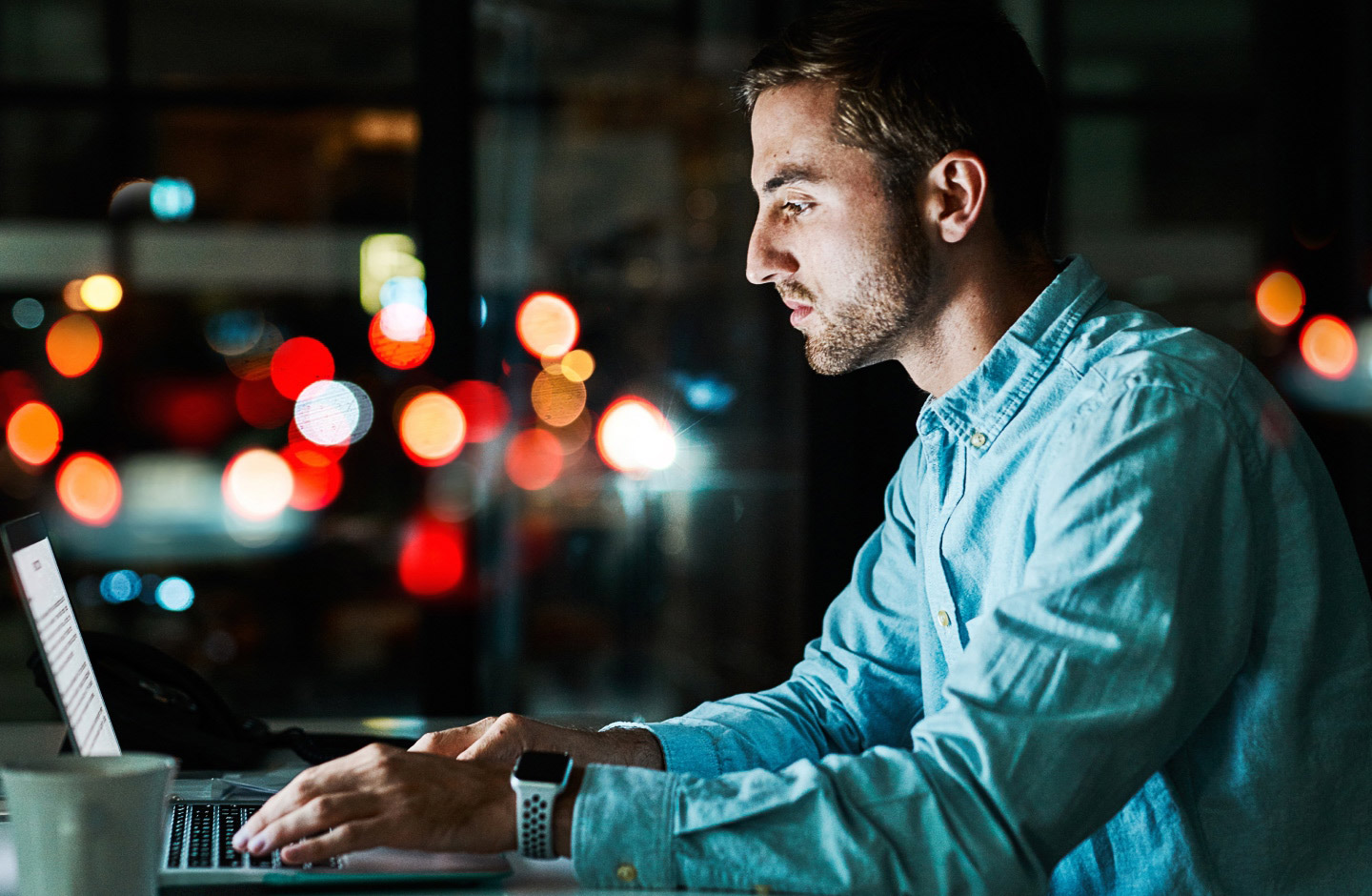 jovem adulto de perfil a teclar em laptop