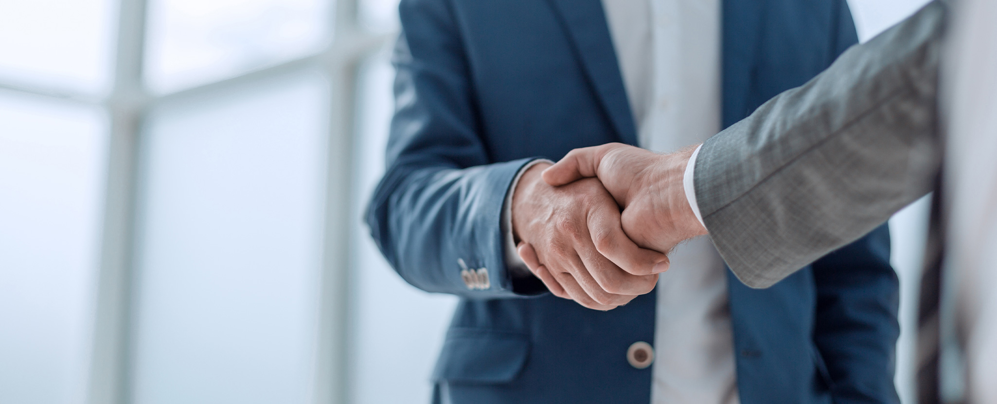 dois homens apertam mãos em acordo