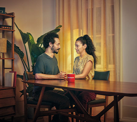 Casal Sentado à mesa a olharem um para o outro