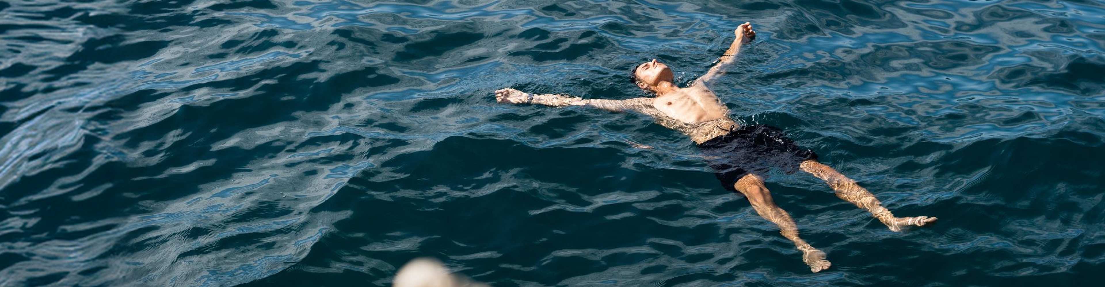 homem flutua no mar