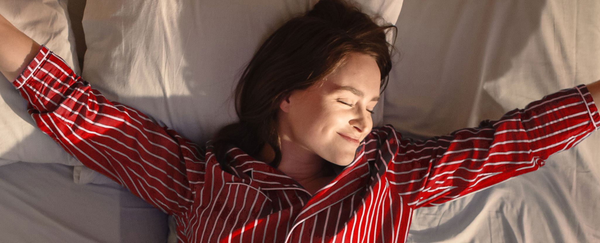 Mulher estica os braços ao acordar