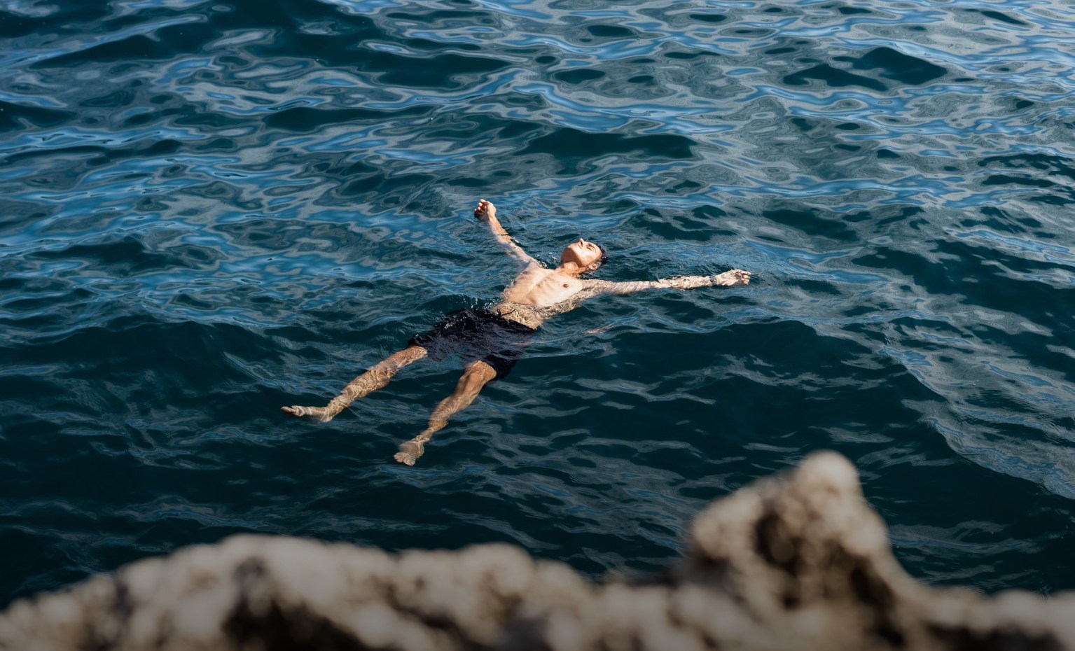 homem flutua no mar