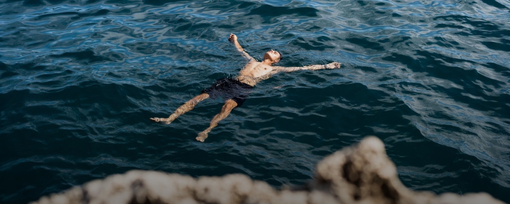 homem flutua no mar