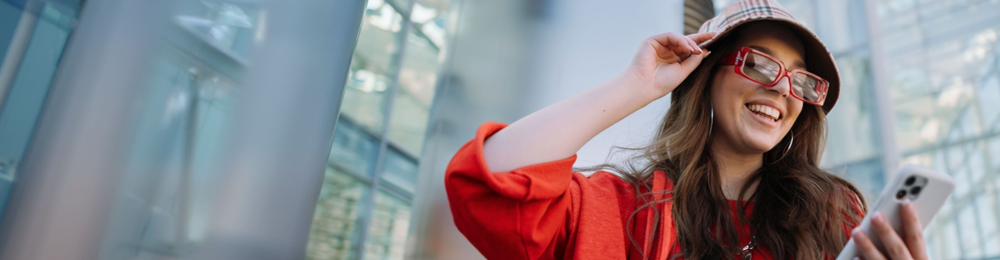 Mulher sorridente com o seu cartão de crédito Santander