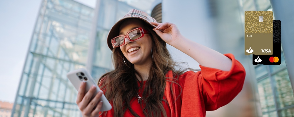 Mulher sorridente com o seu cartão de crédito Santander