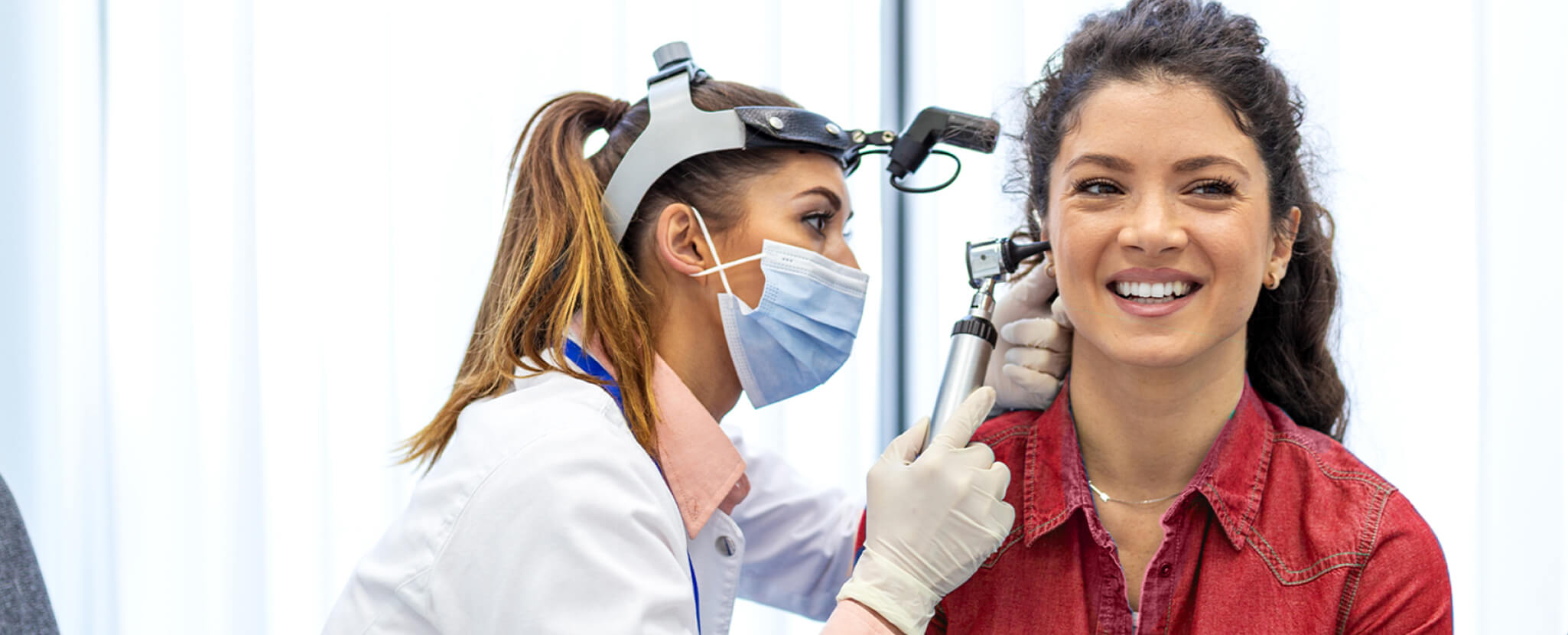 Otorrinolaringologista examina o canal auditivo de paciente