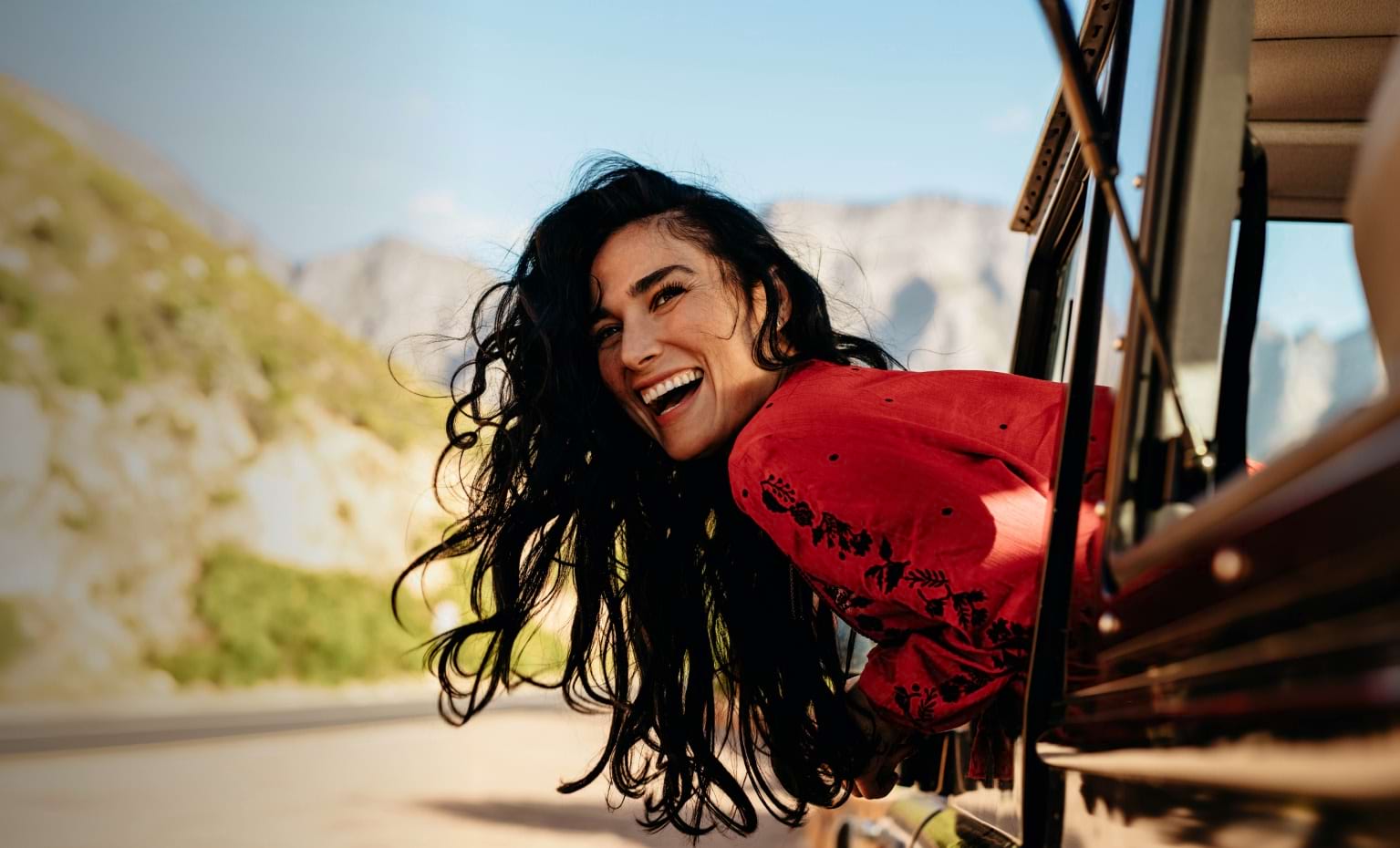Mulher feliz do lado de fora da janela do carro