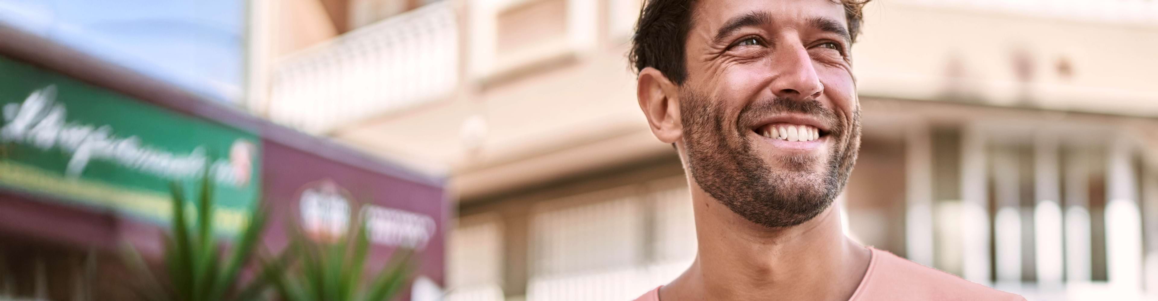 Homem sorridente com smartphone na mão