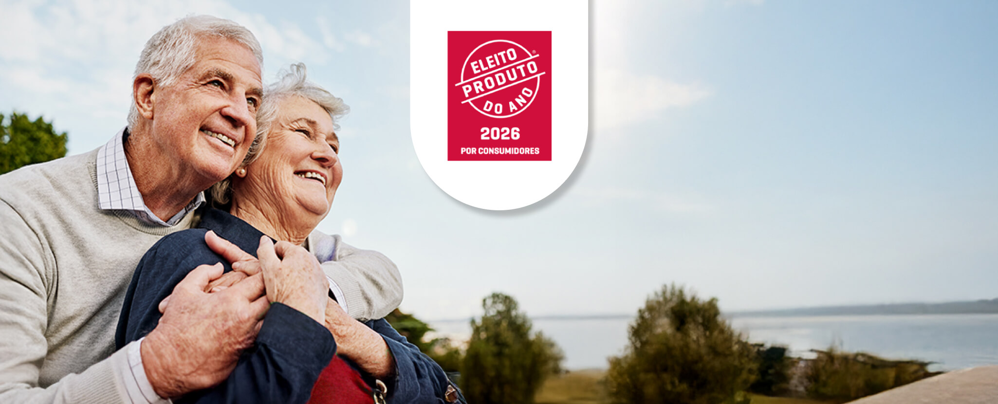 Casal sénior abraçados e selo Produto do Ano 2026
