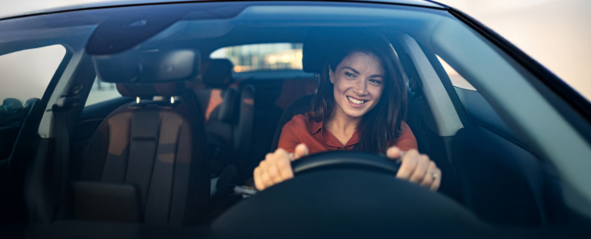 Mulher conduz carro com ar feliz