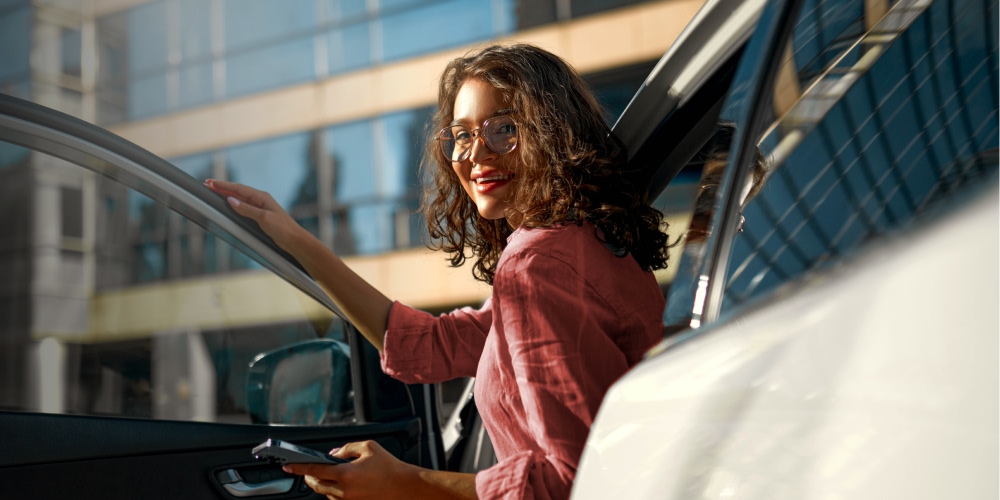 Mulher sorri dentro do automóvel