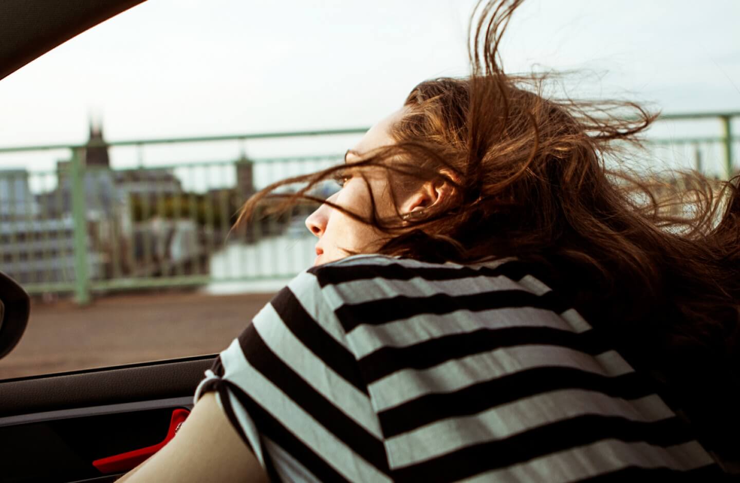 Mulher observa paisagem dentro de um automóvel