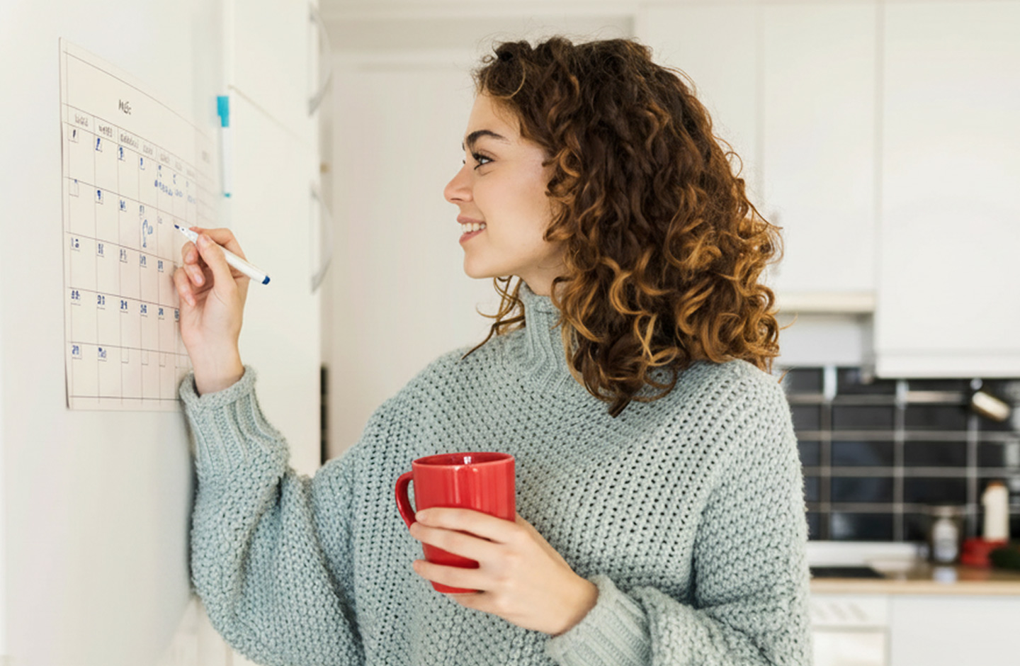 mulher escreve em calendário de parede