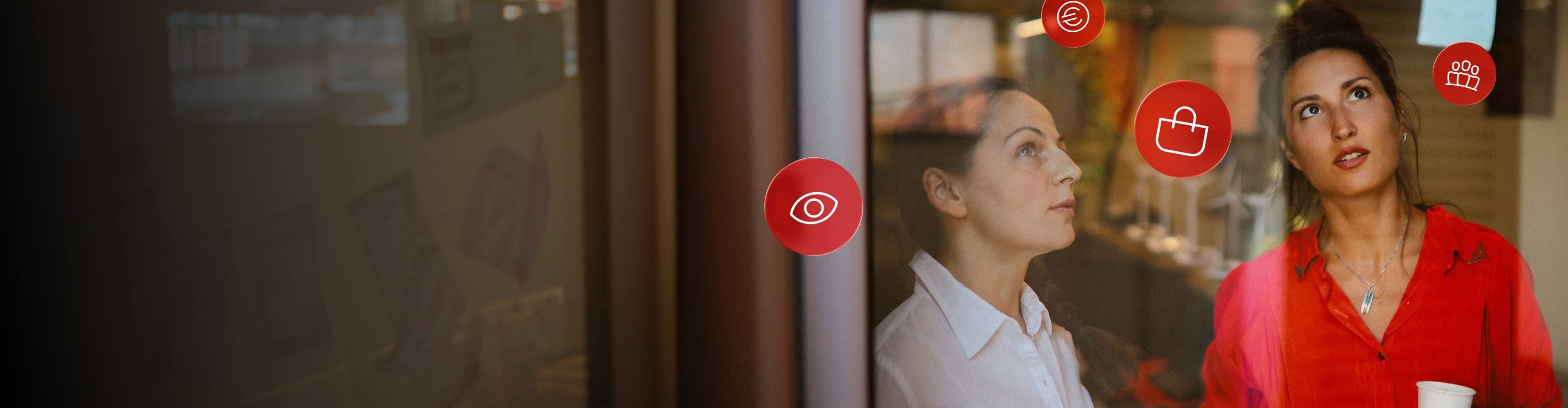 Duas mulheres consideram as vantagens de Santander Rewards para Empresas