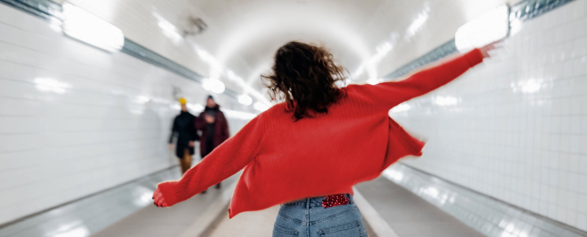 Mulher de braços abertos numa estação de metro