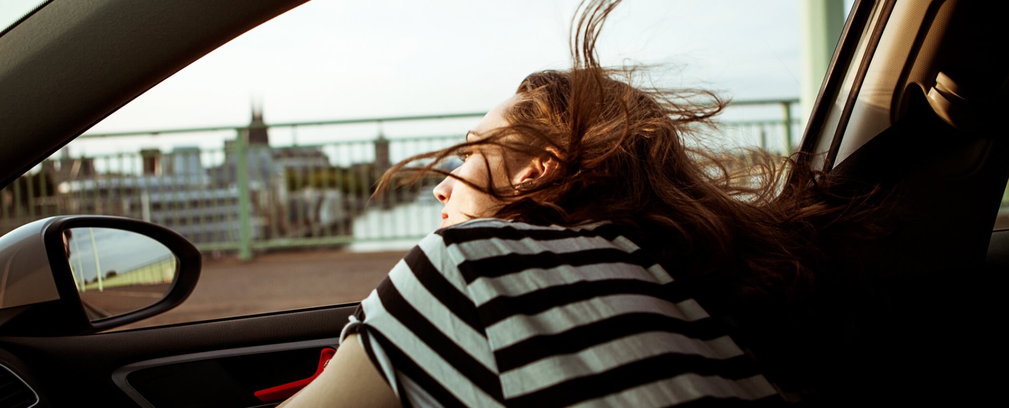 Mulher observa paisagem dentro de um automóvel