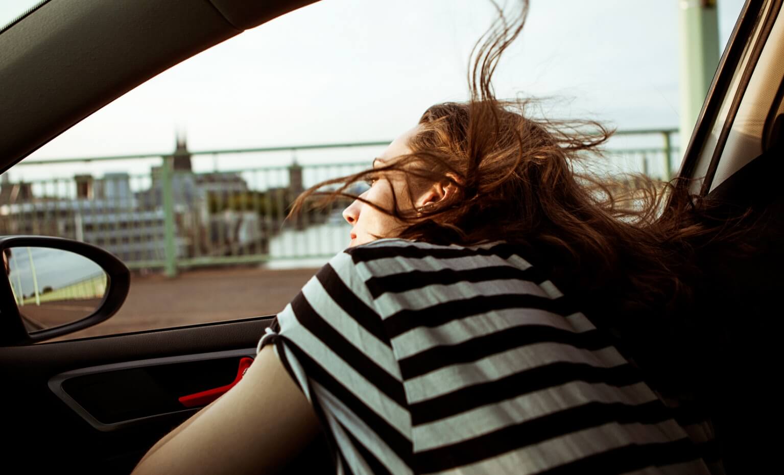 Mulher observa paisagem dentro de um automóvel