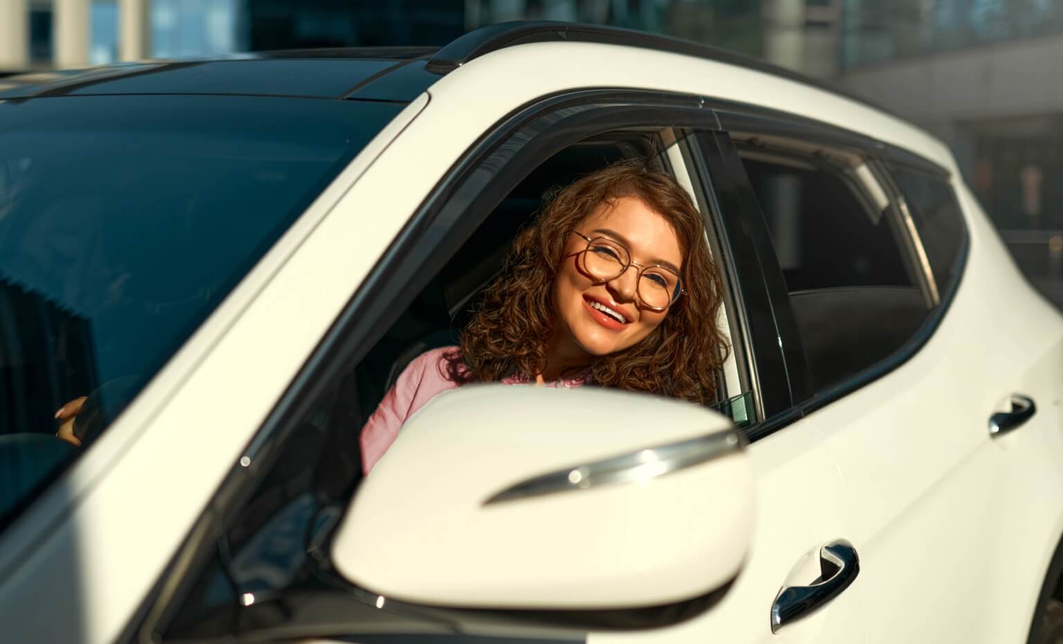 Mulher sorri dentro do automóvel