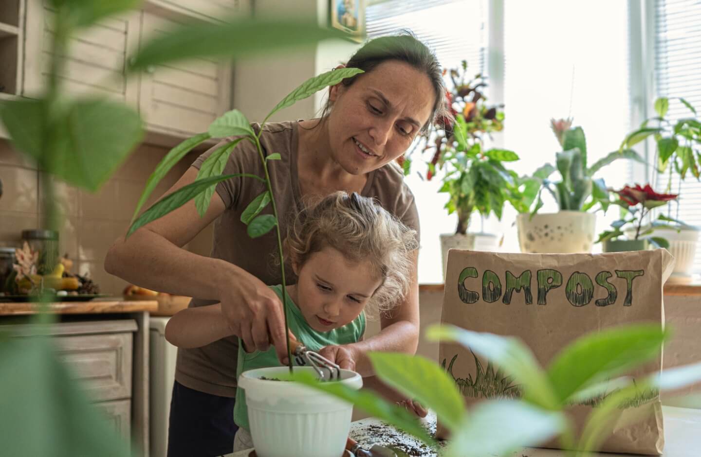 Mulher ensina criança a plantar em vaso