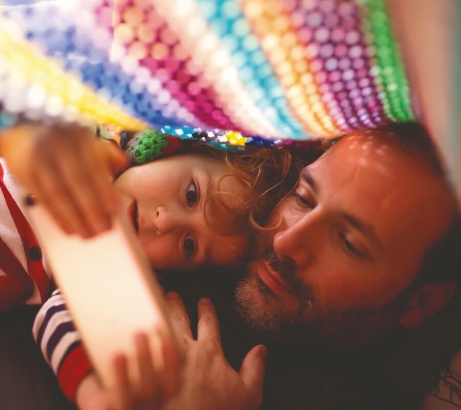 Pai e filha vêm algo no smartphone