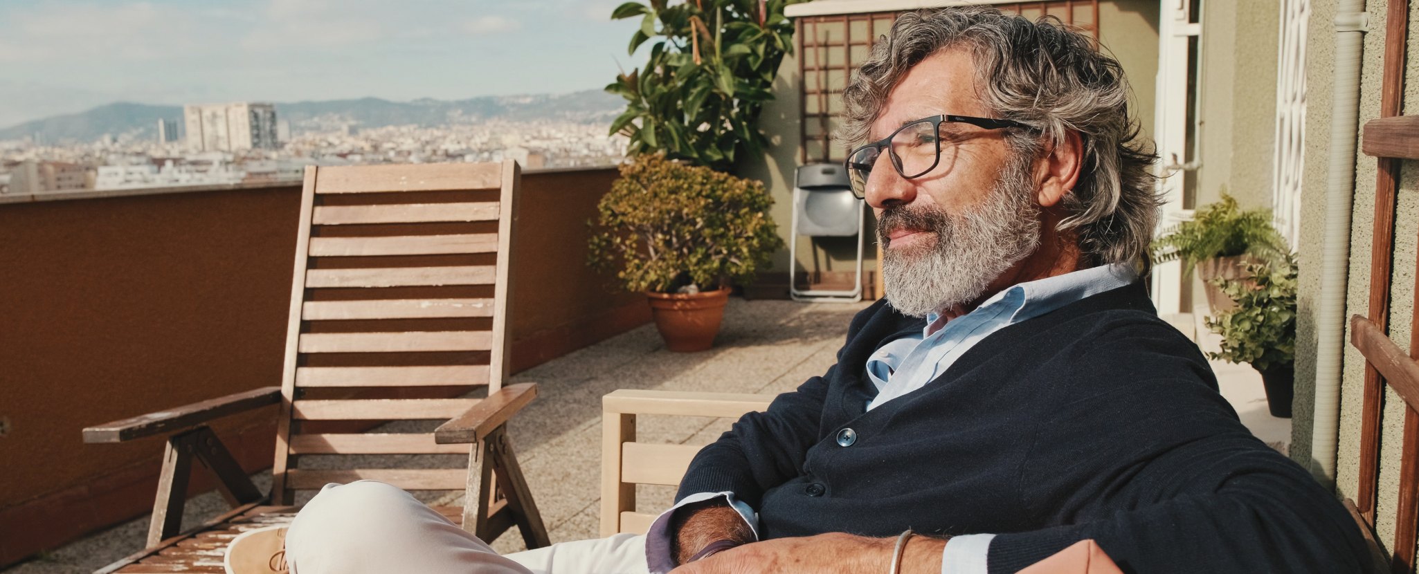 Cidadão sénior na varanda de sua casa contempla investimentos de baixo risco no Santander