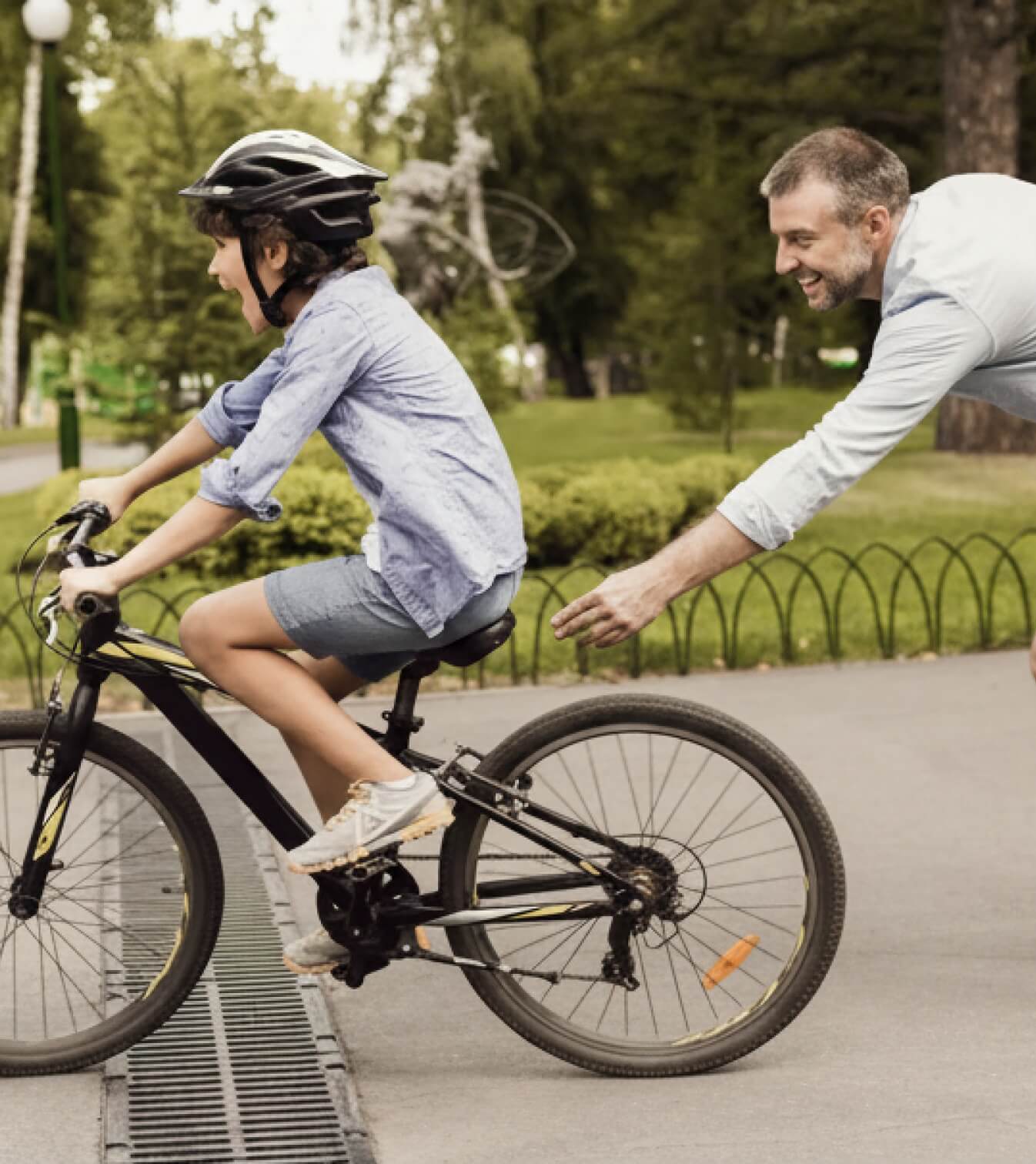 Pai ensina filho a andar de bicicleta