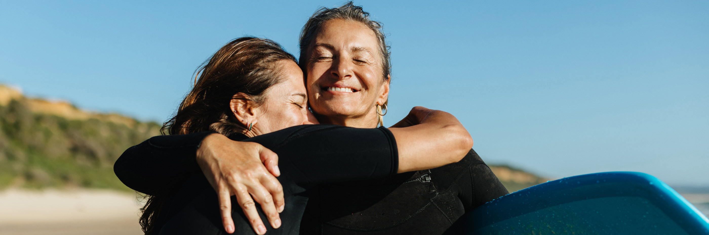 casal de duas mulheres abraçadas na praia