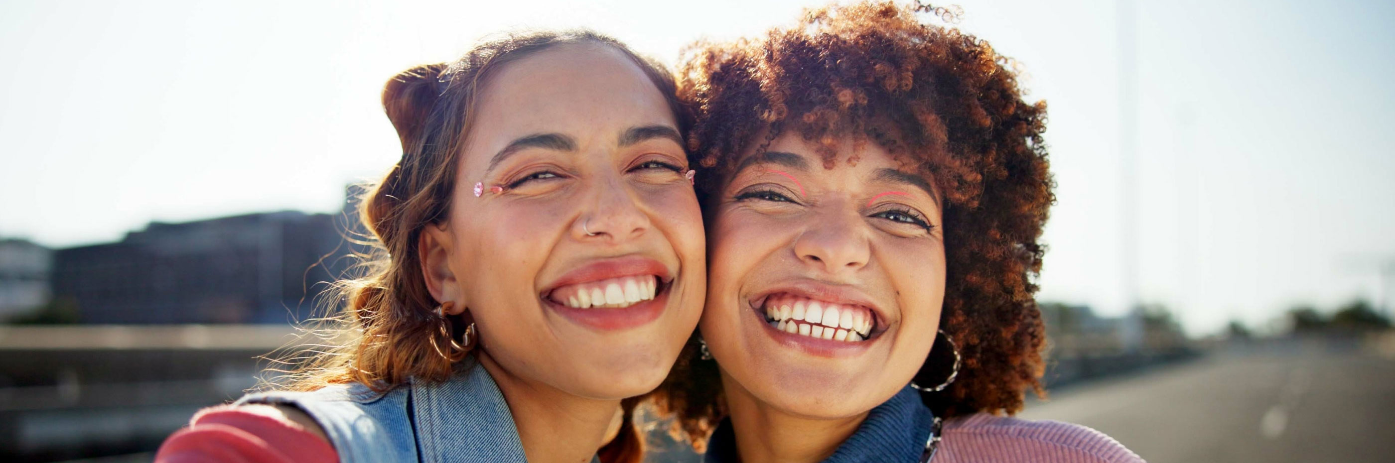 duas jovens abraçadas e sorridentes