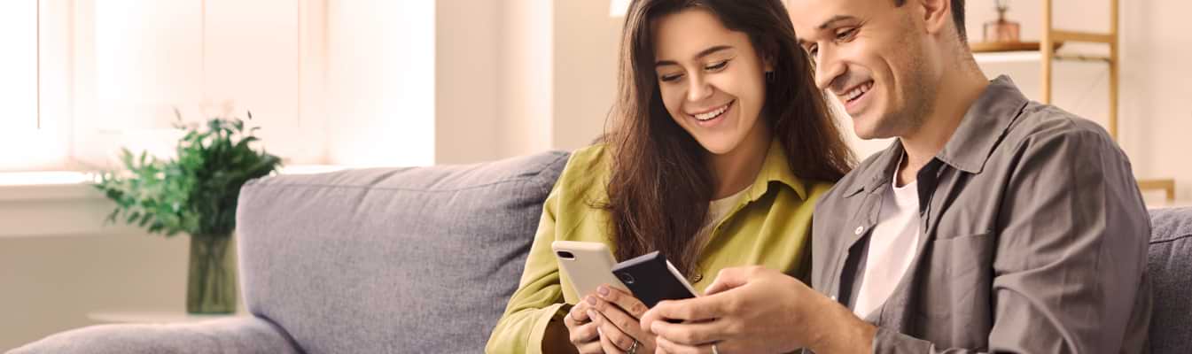 Casal de homem e mulher mostram conteúdo no smartphone
