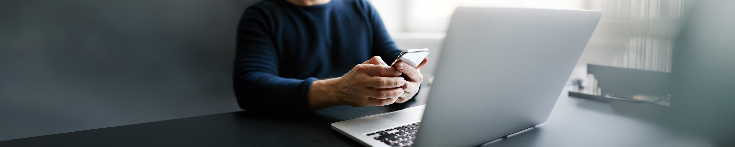 Pessoa a consultar o smartpPessoa a verificar no smartphone o código de consultahone e computador