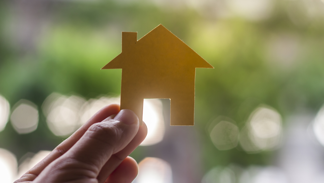 Mão a segurar uma casa de papel 