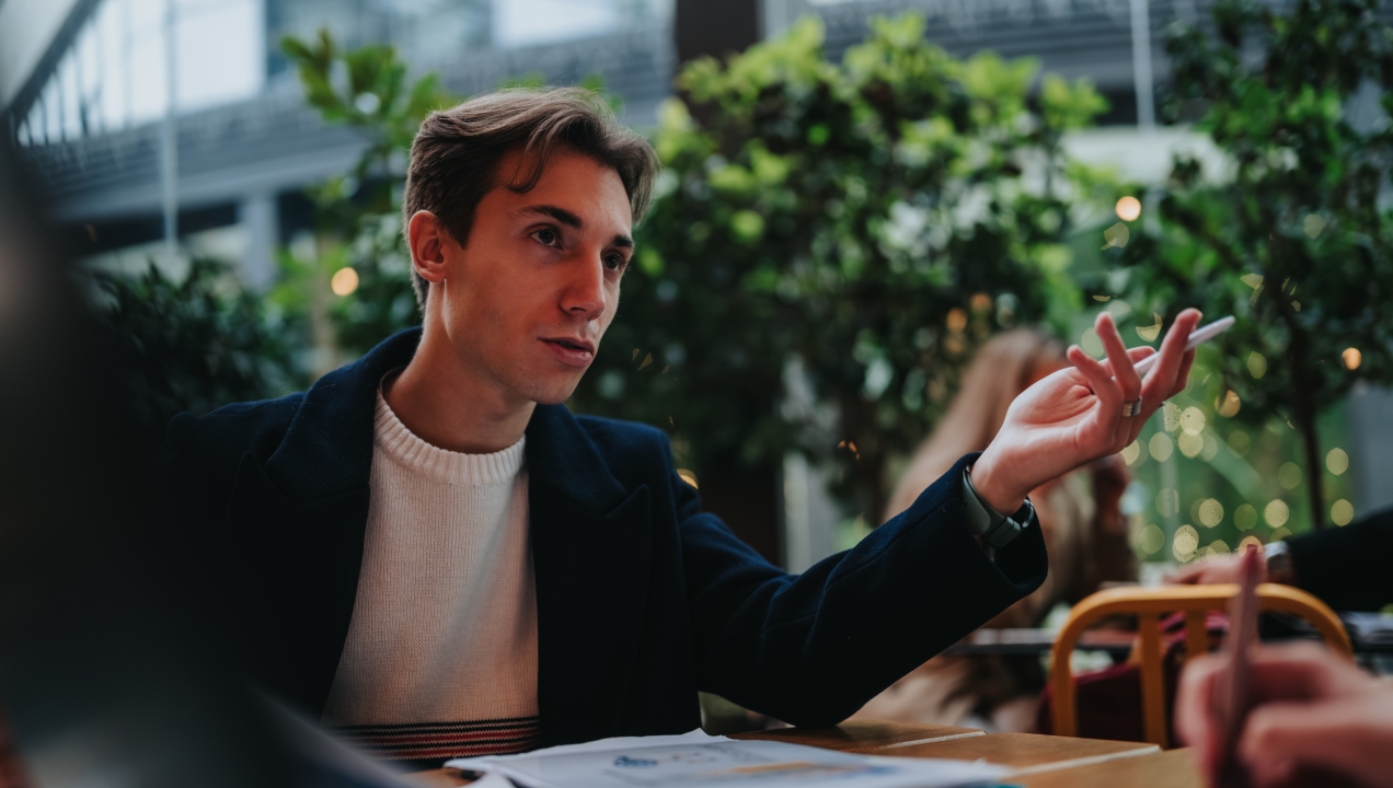 Senhor sentado à mesa a conversar sobre situação financeira