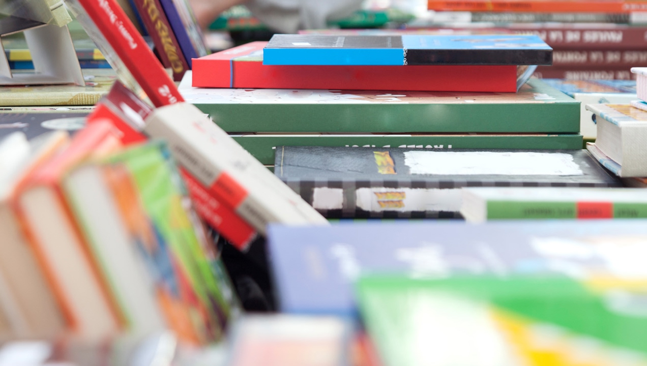 Vários livros dispostos numa banca 