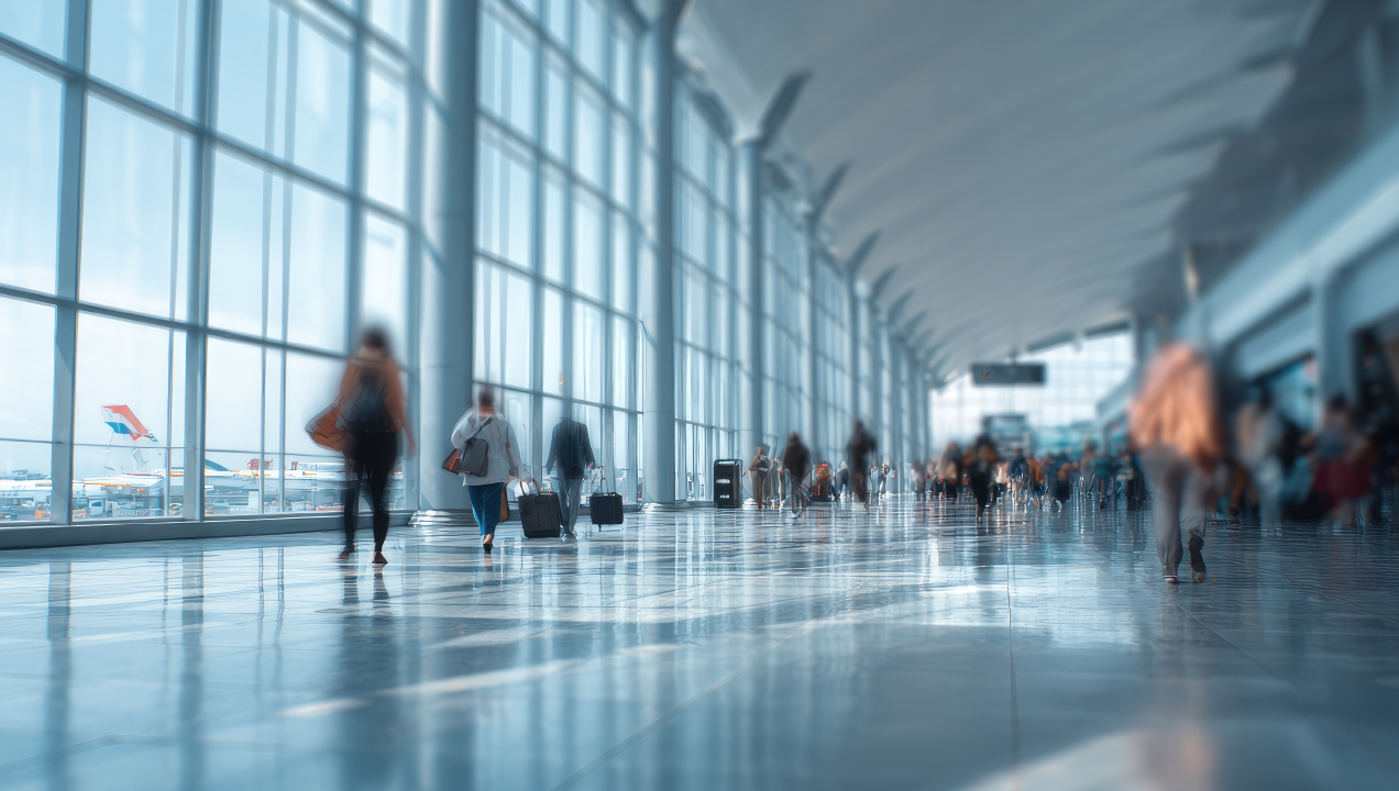 Passageiros com malas a circular num corredor amplo de um aeroporto