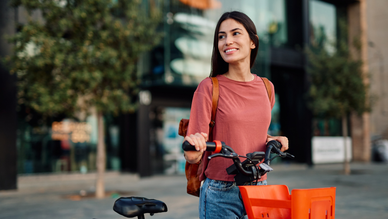 Senhora feliz a segurar a sua bicicleta elétrica
