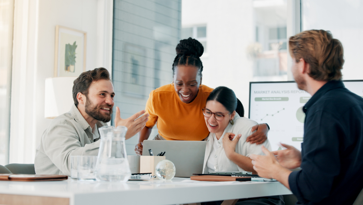 Colegas de trabalho felizes numa reunião devido a bom desempenho