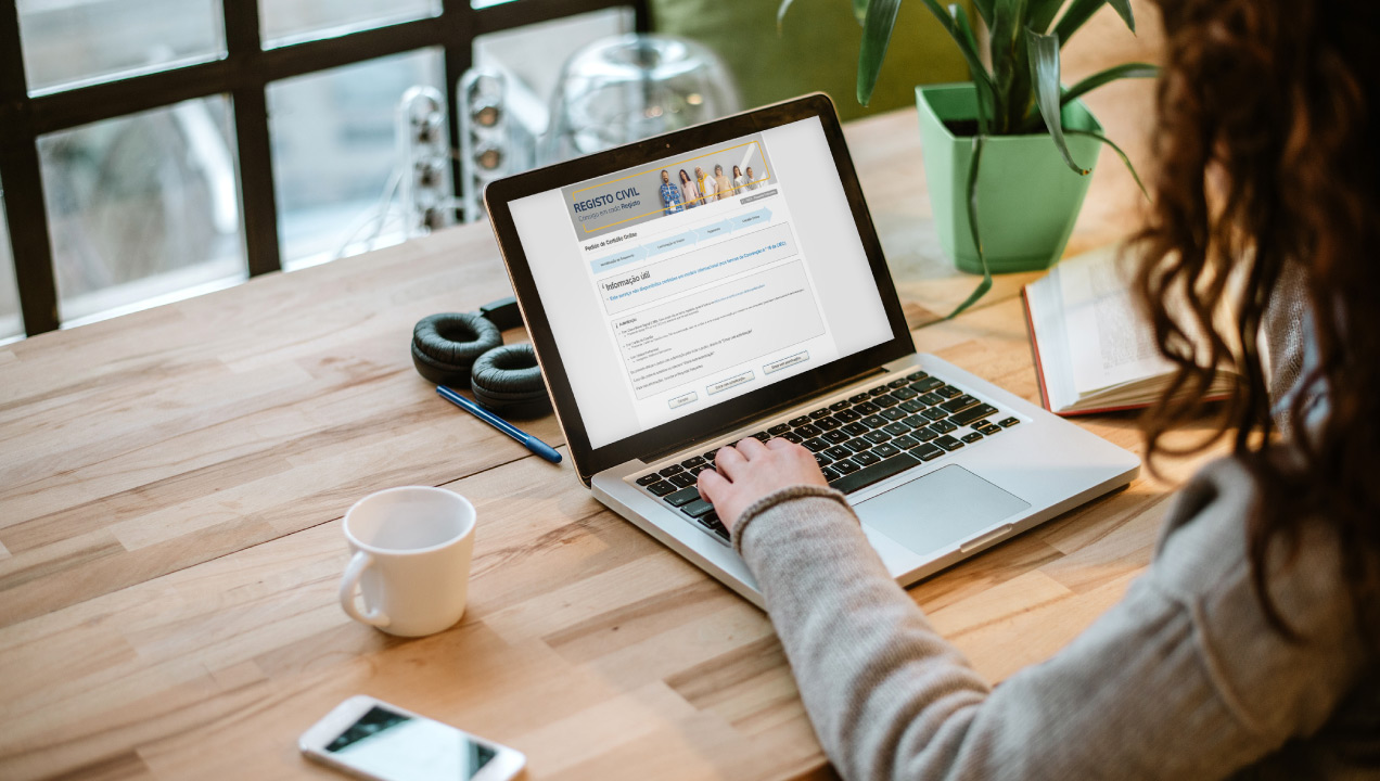 Senhora sentada na secretária a mexer no computador