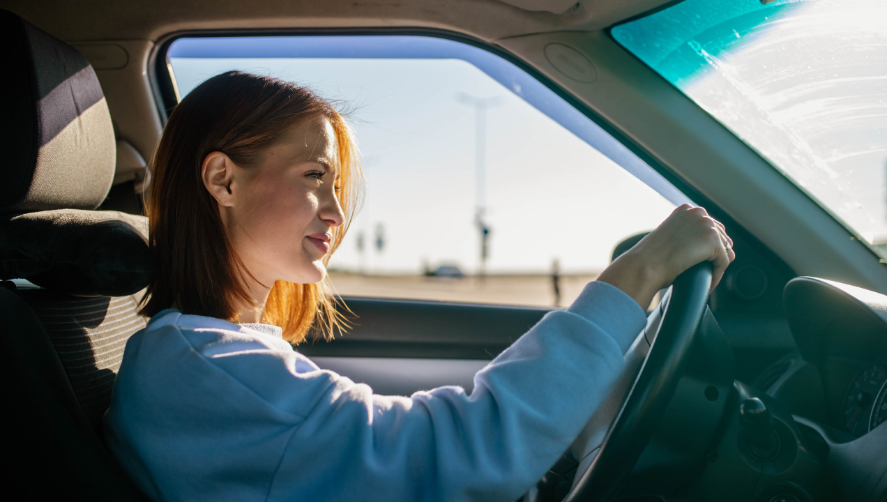 Senhora feliz a conduzir o seu carro