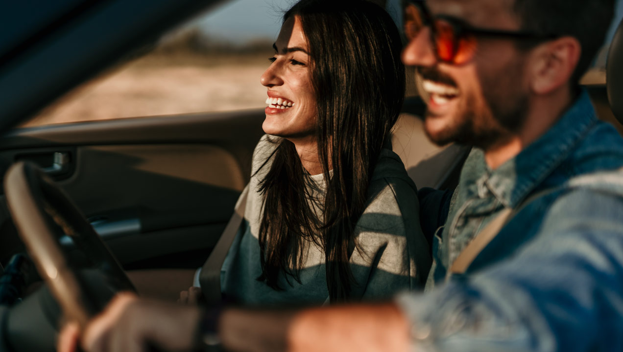 Casal animado a andar de carro
