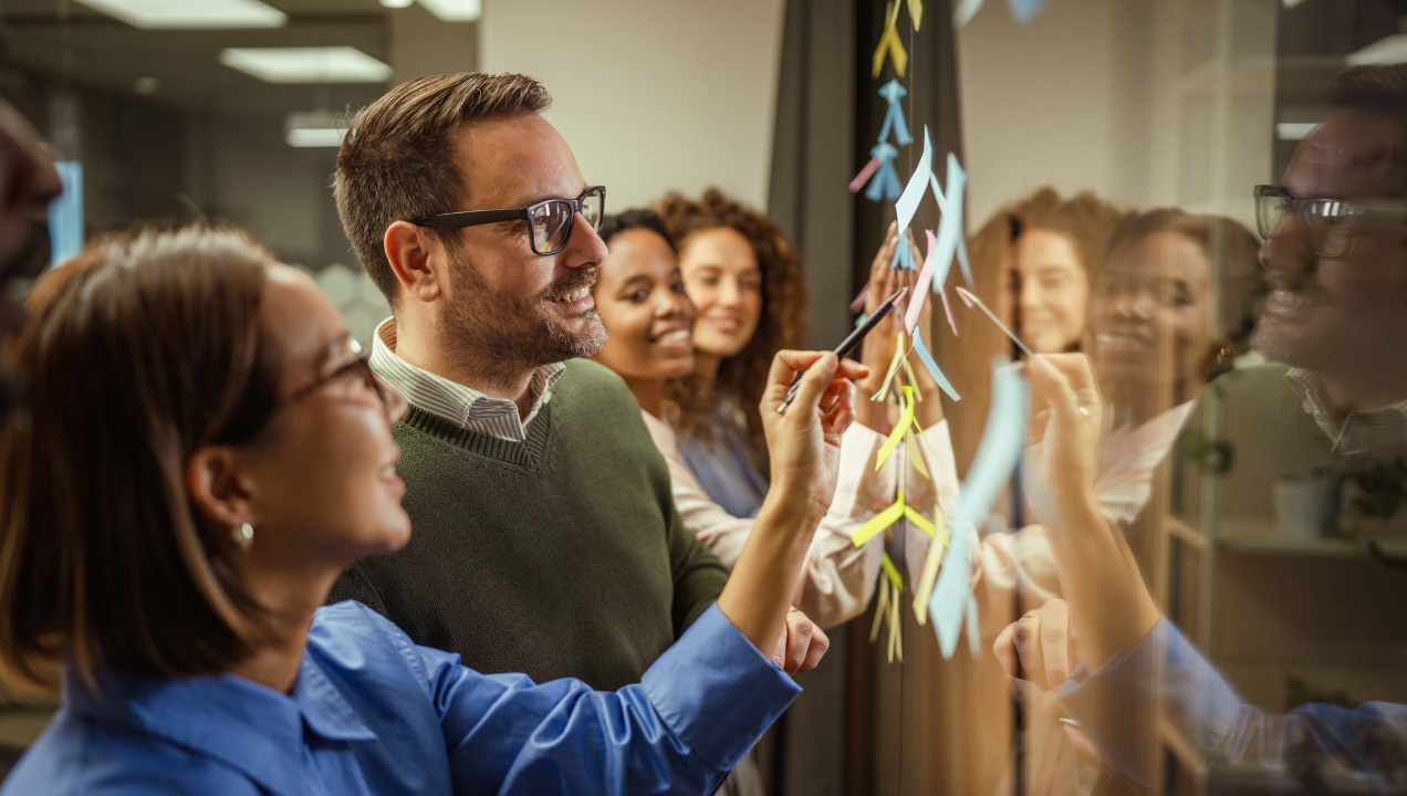 Equipa em reunião de trabalho a olhar para notas em post-its coloridos