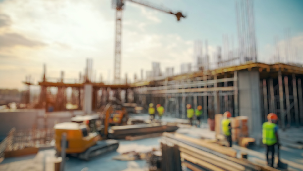 Construção de edifício com gruas, máquinas e trabalhadores com coletes e capacetes