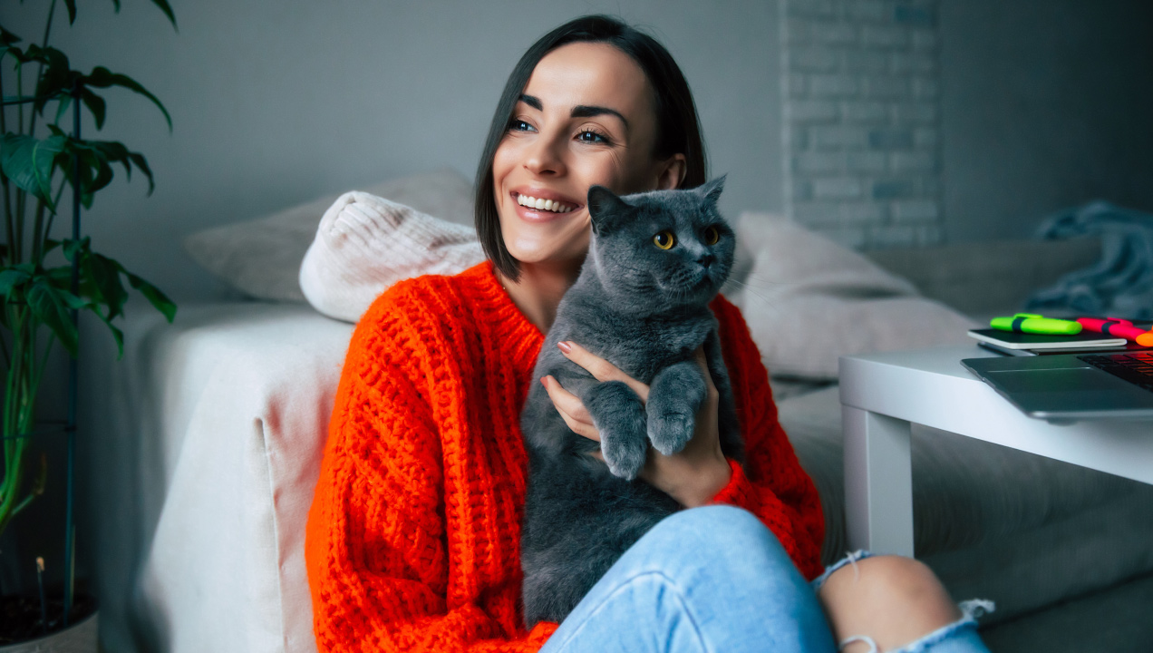 Senhora feliz sentada agarrada ao seu gato