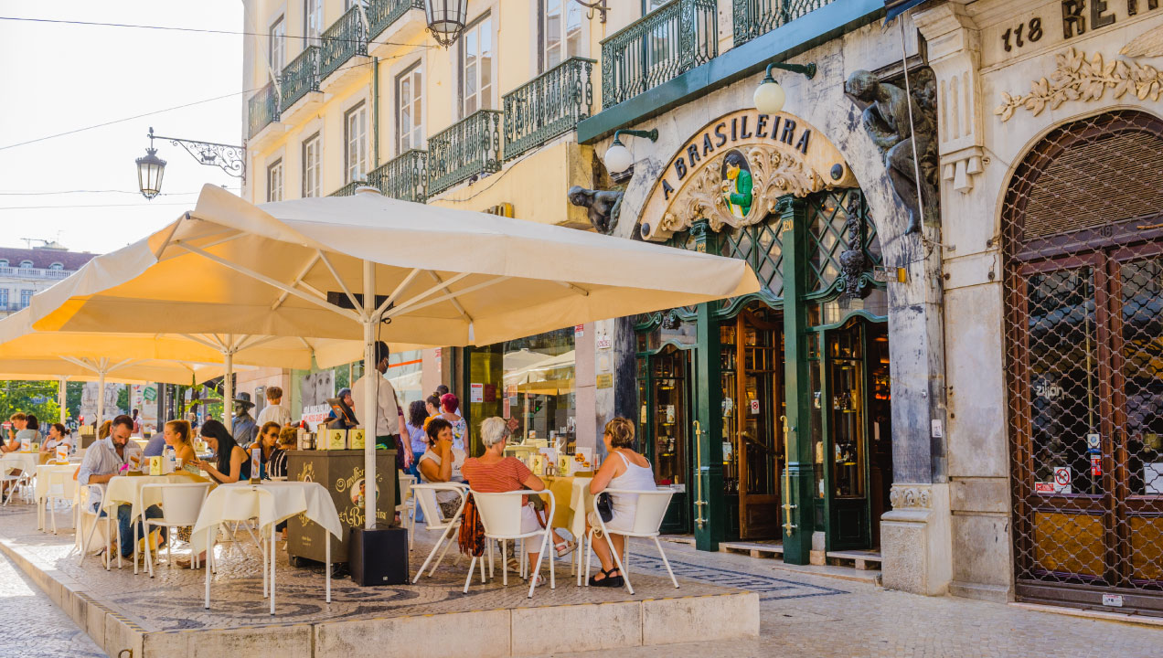 Esplanada da histórica loja A Brasileira, em Lisboa, com clientes sentados no exterior