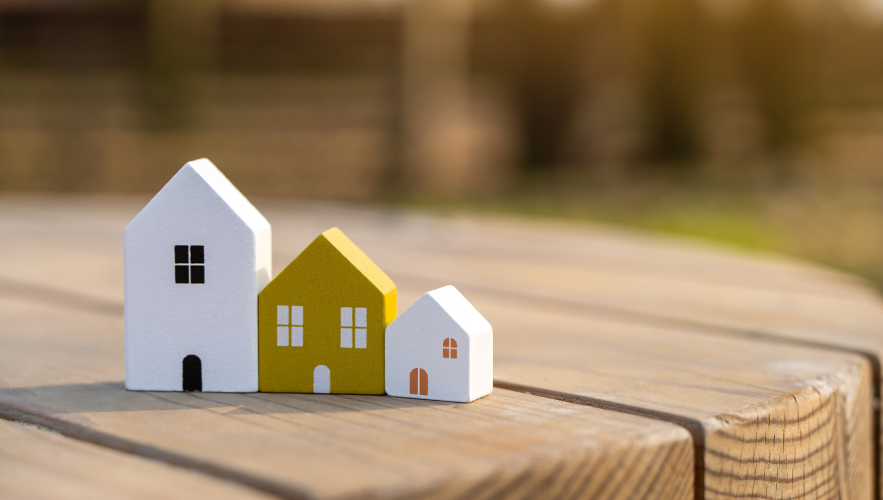 três casinhas de madeira pequenas numa mesa de jardim