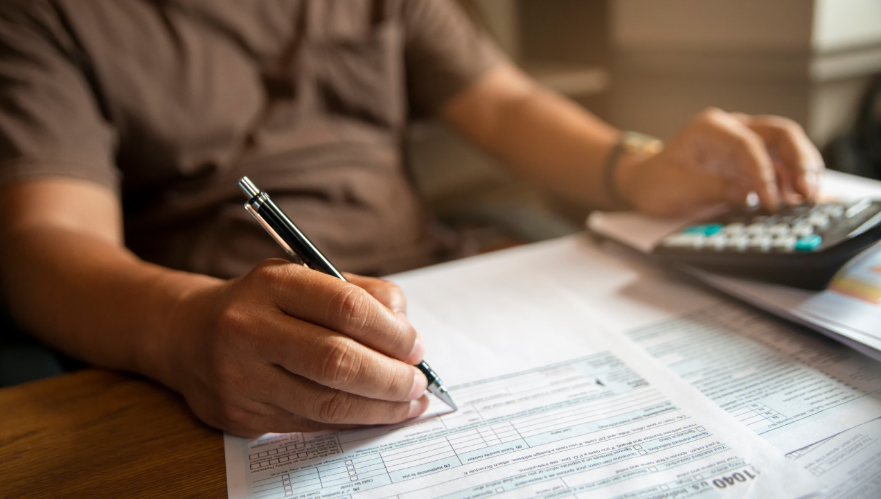Senhor sentado a preencher o modelo 1 do IMI 