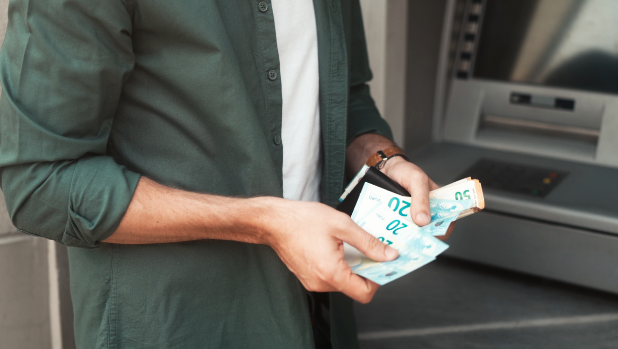 Senhor a contar notas de 20 e 50 euros