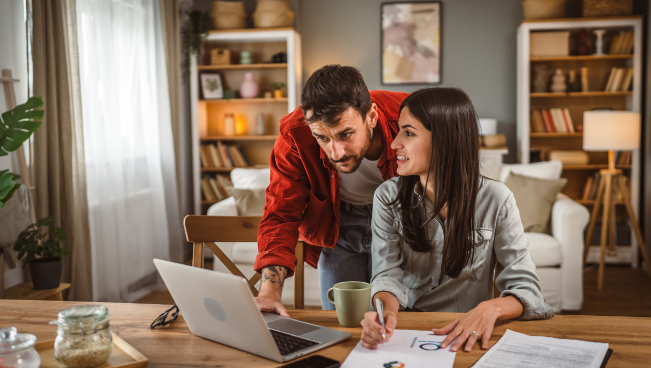 Casal em casa a analisar e organizar as finanças
