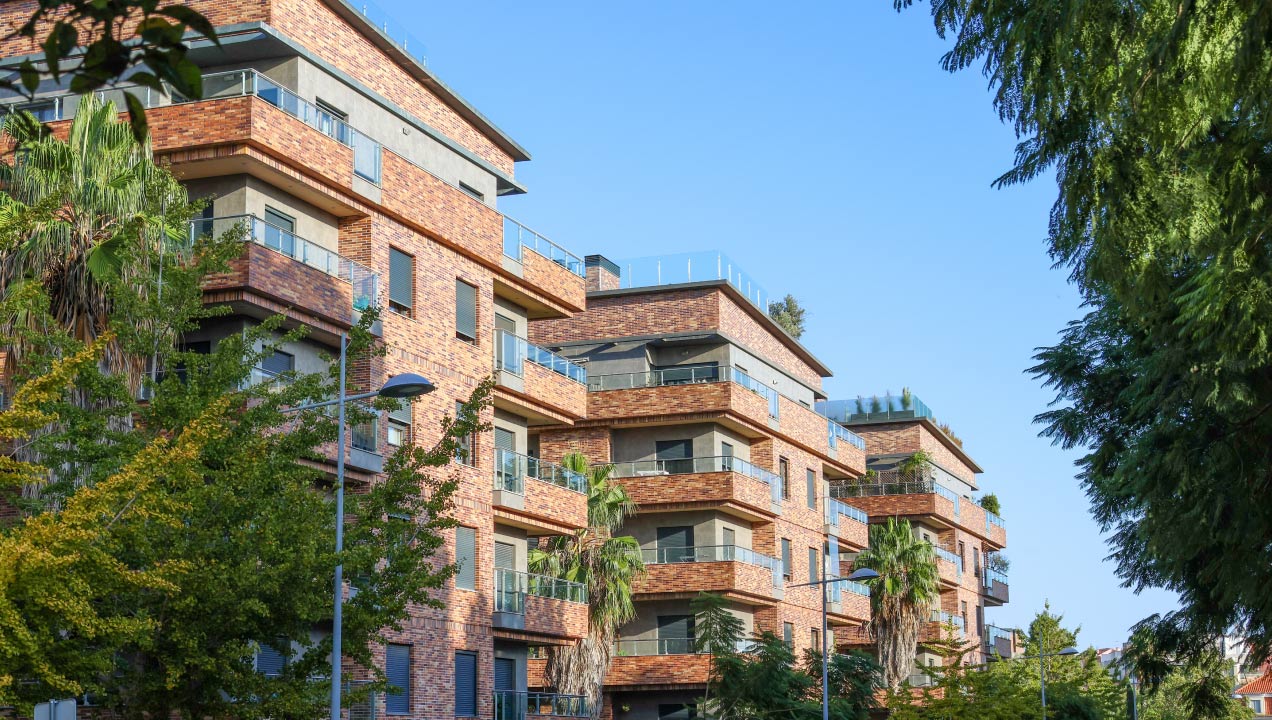 Edificio residencial com vários andares rodeado de árvores