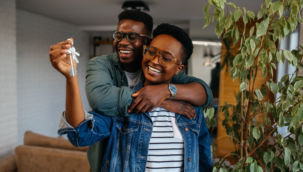 Casal feliz com com uma chave de casa na mão